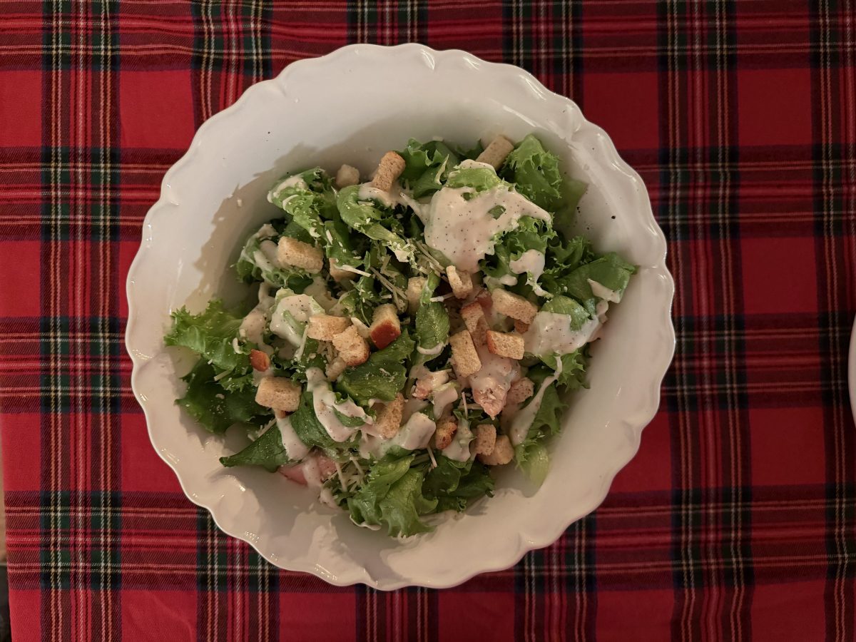 Overhead Ceasar Salad on red plaid tablecloth setting